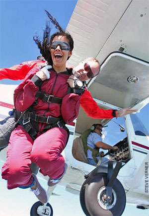 Tandem skydiving pair exits a Cessna 182. 